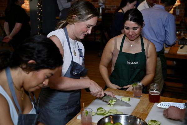 Three women participating in a cooking class at The Kitchen