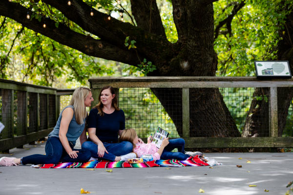 Two moms and their daughter enjoy a family picnic