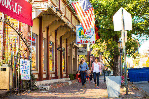 Two women walking and holding hands by the Book Loft in German Village