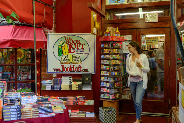 Woman walking out of The Book Loft with purchased books