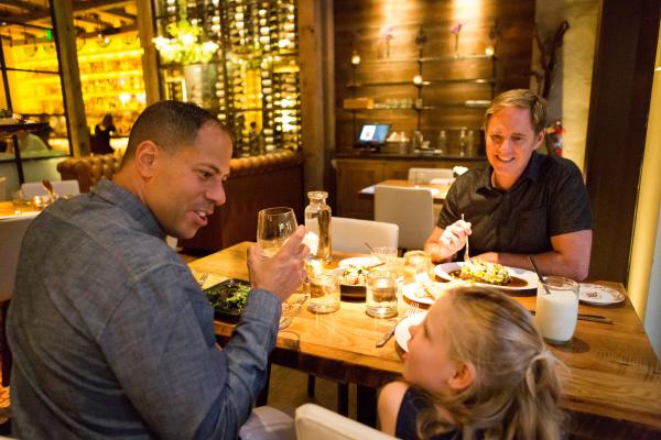 Two dads dining at the Guild House with their daughter