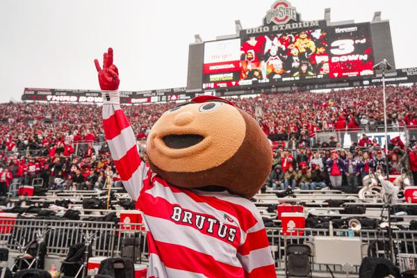 Brutus in the Ohio Stadium with crowd behind him