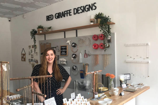 Kate Stevens poses in her shop, Red Giraffe Designs