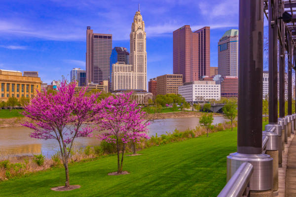 Columbus skyline along the Scioto Mile during spring with blooming pink trees
