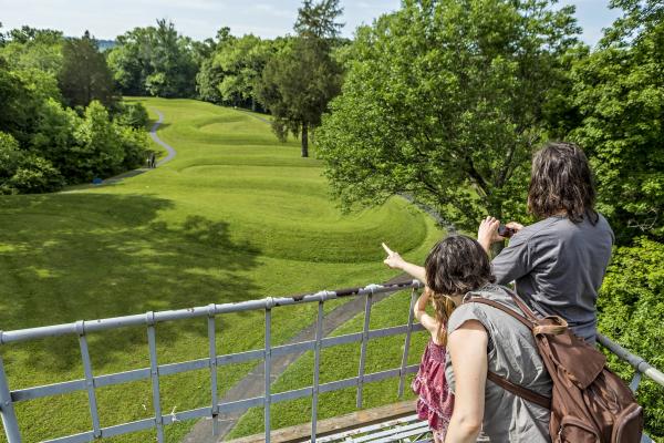 A photo of Serpent Mound from above with three visitors