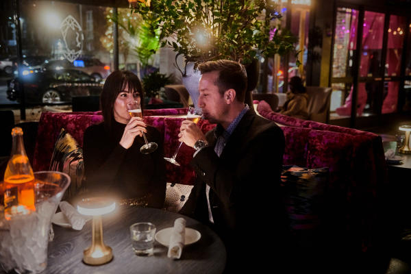 Man and woman sipping champagne during a restaurant date