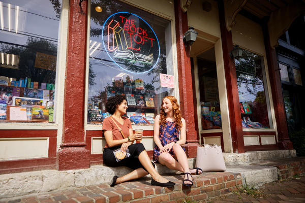 Two friends sitting outside The Book Loft in German Village