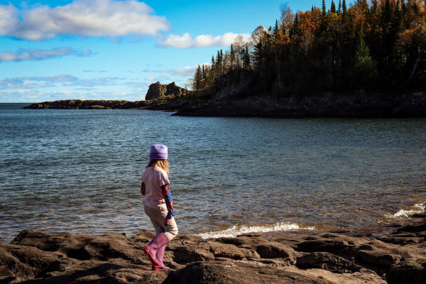 A little girl walks along the rocks at Sugarloaf Cove