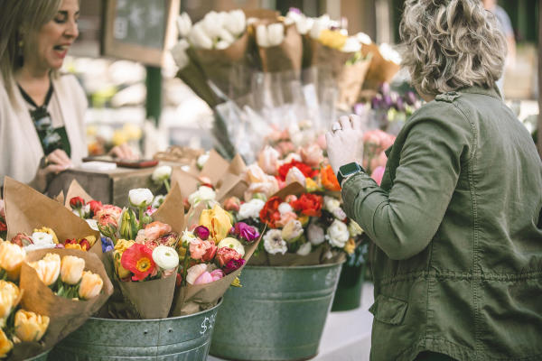 A woman shopping fresh floral bouquets at the Dublin Market