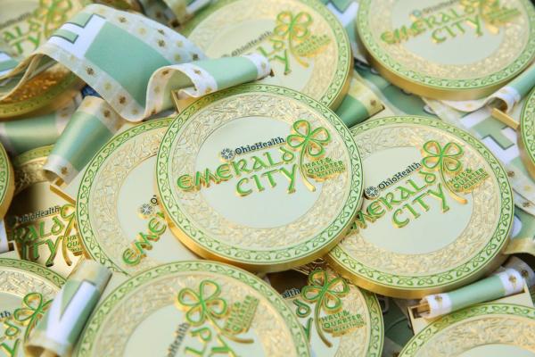 A pile of Emerald City Quarter and Half Marathon finsher medlas