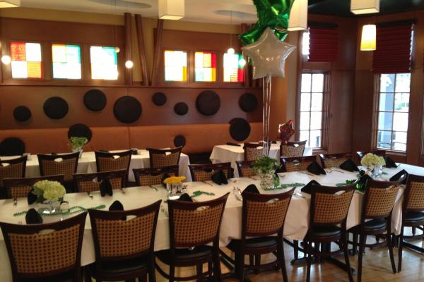 J. Liu's private dining room has long tables, white linens, and colorful accents, including balloons and stained glass windows.