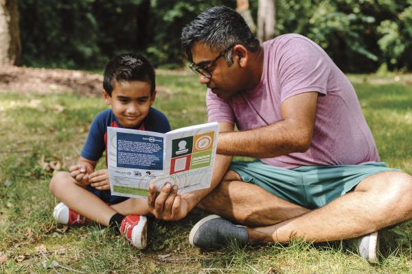 Father and son looking at the Riverboxes guide book