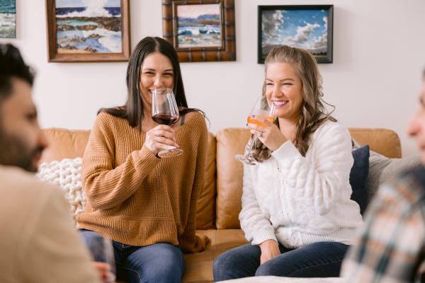 Two girls enjoying wine on the couch at Coast Wine House