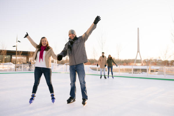 Two couples ice skating in Riverside Crossing Park
