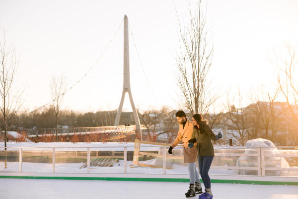 A couple ice skating on the ice rink at Riverside Crossing Park