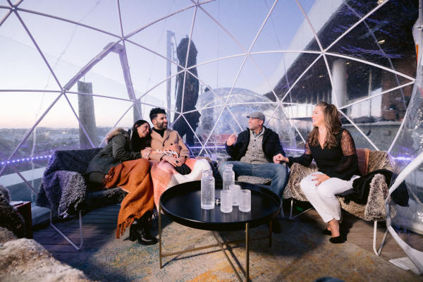 Two couples conversating inside the VASO Rooftop Igloos