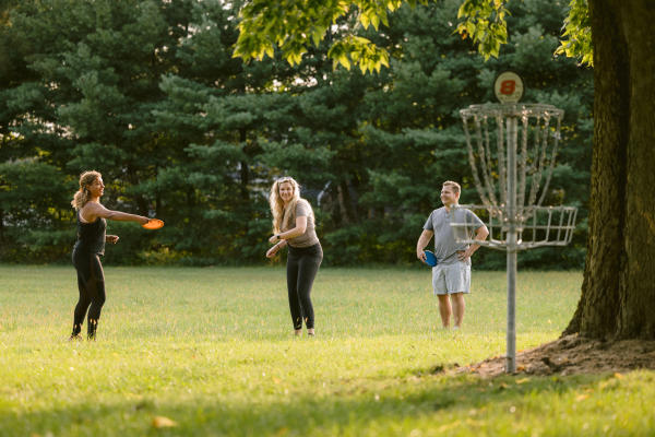 A group of people playing frisbee golf