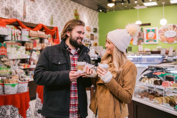 Couple sipping hot chocolate and sampling fudge at Kilwins in Bridge Park