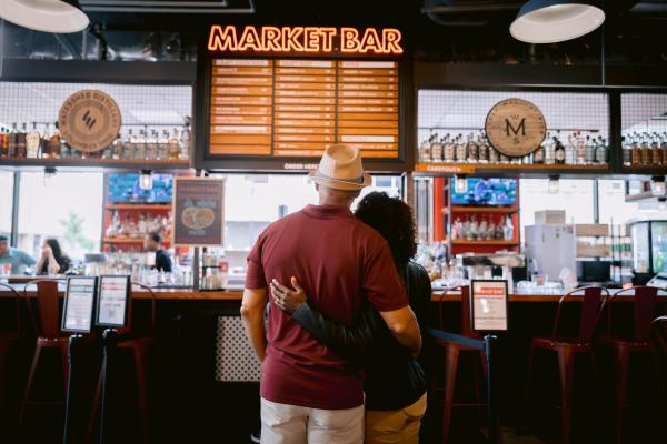 A couple embracing in front of the Market Bar at North Market Bridge Park