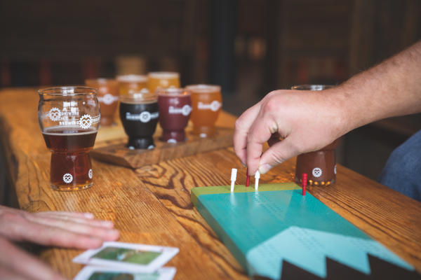 Flights of beer and a hand playing cribbage at The Brewing Projekt