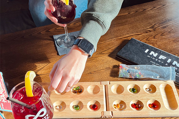 Two girls playing Mancala and drinking Sangria at Infinity Beverages Winery & Distillery in Eau Claire