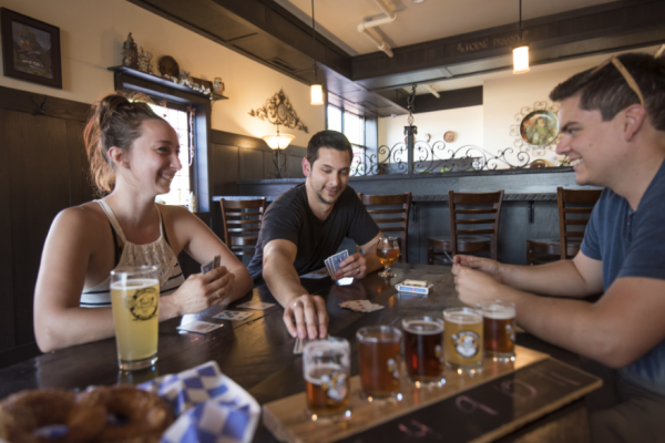 A group enjoying a game of cards and flights of beer at Lazy Monk