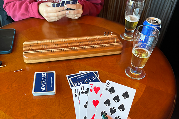 Two women playing cribbage and drinking beer at The Waiting Room in downtown Eau Claire