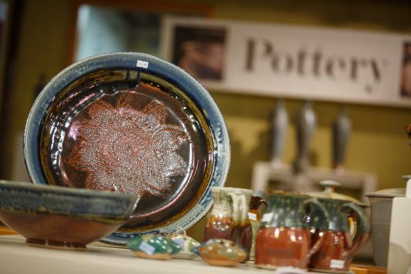 A handmade ceramic platter, along with cups and bowls, on display at Goertzen Pottery.