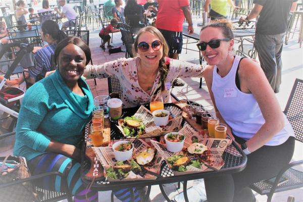 Three women enjoying lunch and drinks together on the outdoor patio at Dirtbag Ales in Cumberland County, North Carolina.