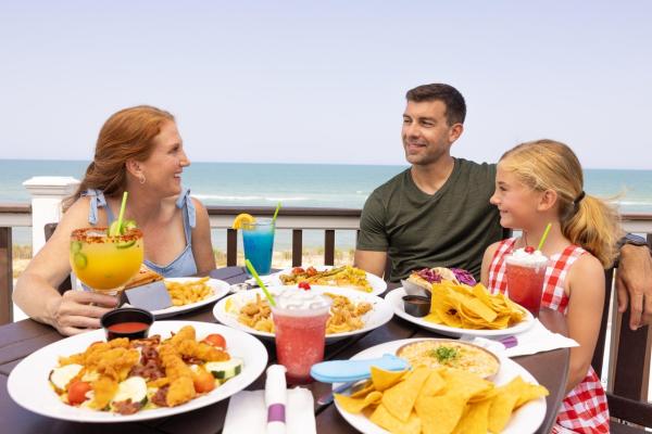 A mom, dad, and daughter enjoy lunch at Oceanside Beach Bar and Grill in Flagler Beach,