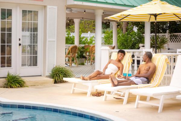 A man and woman sit on loungers at the charming Island Cottage Inn in Flagler Beach. The adults-only inn features nine guest rooms and private beach access.
