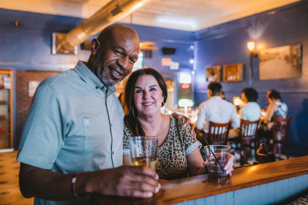 Couple is smiling with drinks at Prohibition Bar in Fort Smith.