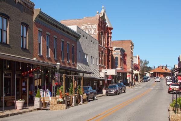 Cars line the edges of the Main Street as the sun casts a shadow on the old brick buildings in Downtown Van Buren.