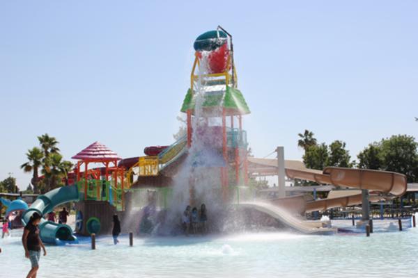 Kids being splashed by large water fall at Island Water Park