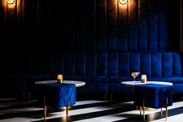 Plush navy blue velvet banquettes with a martini on a cocktail tables