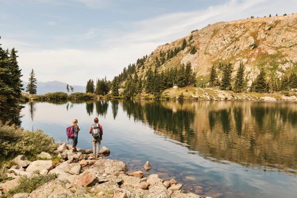 Hikers standing next to an alpine lake in the backcountry