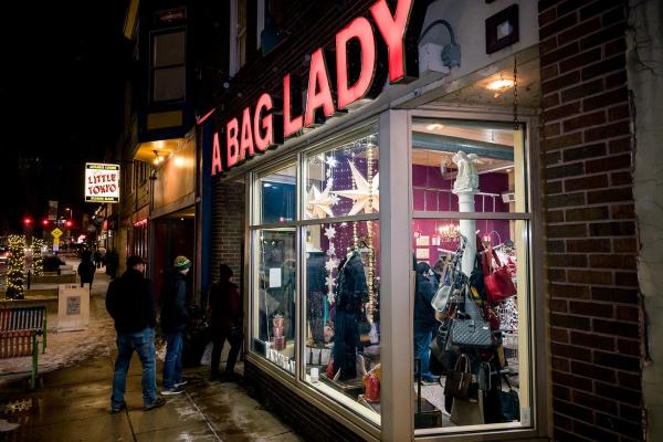 Group walking into a downtown storefront on a snowy night