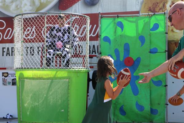 Little girl throwing football at Dunk Tank