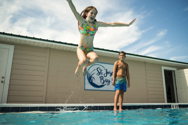 child jumping into pool