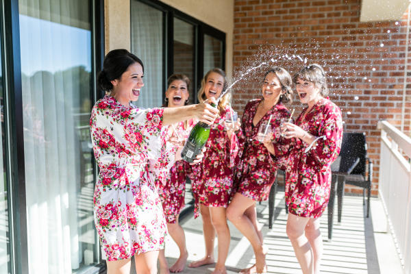 A picture of a bridal group spraying champagne