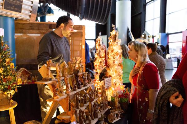 Christkindlmarket Huntsville shopper and vendor talking at a stand