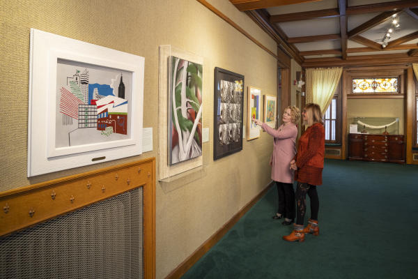 two women pointing at a painting in the Rahr-West Art Museum