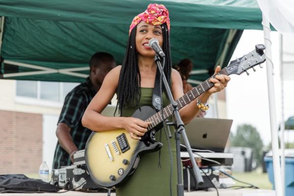 Woman playing guitar and performing at a microphone