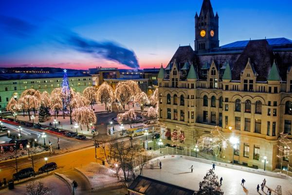 Ice skating rink and historic buildings against a sunset