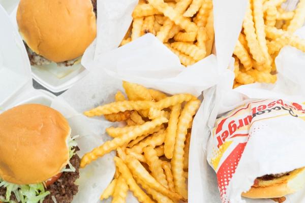 A tray of burgers, sloppy Joe's, and crinkle fries on trays lined with paper from Wagner's Drive-In