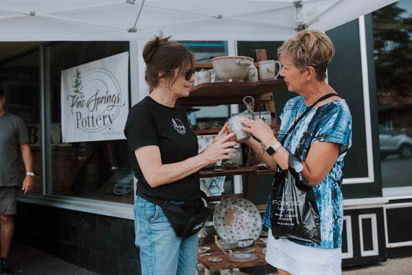 two ladies talking at a vendor stall