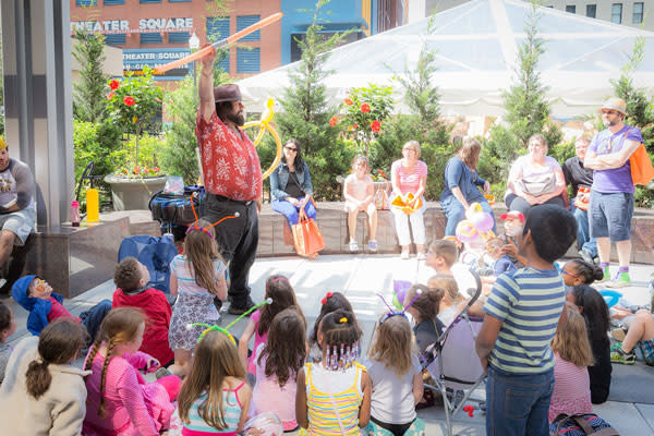 a person in middle talking to kids and people around