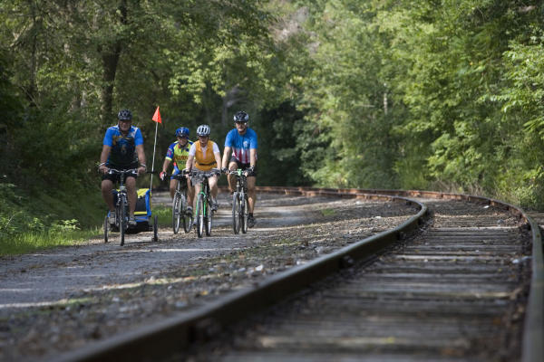 Family group biking next to rail trail