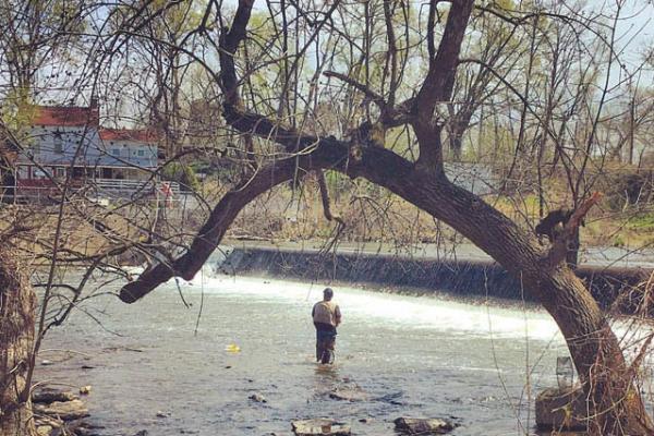 a person standing in the river run fishing