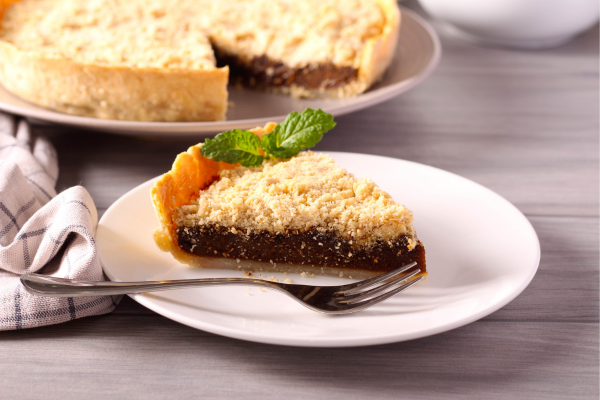 Slice of shoofly pie on plate garnished with mint
